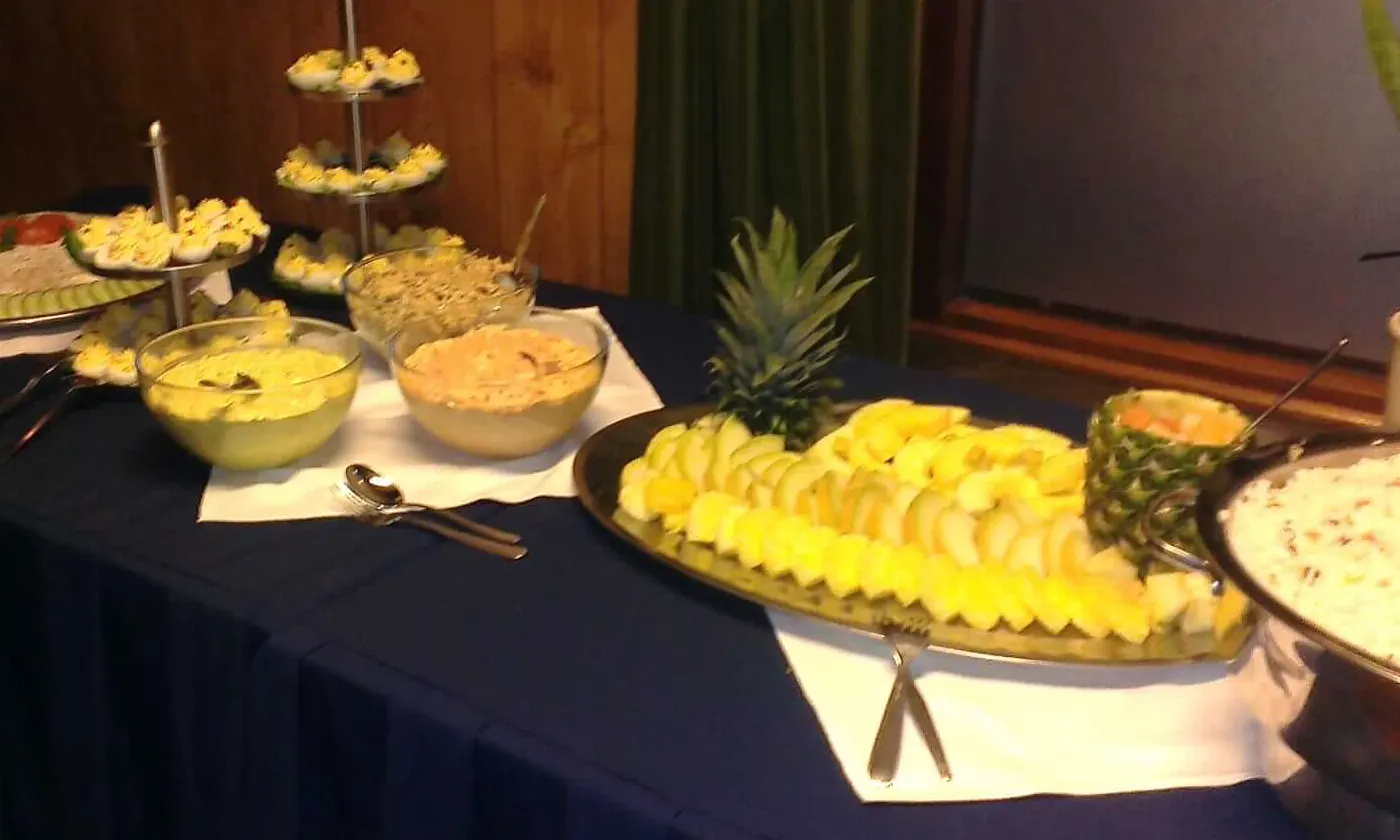 Koud buffet met een etagère gevulde eieren, schalen salade en een schaal fruit